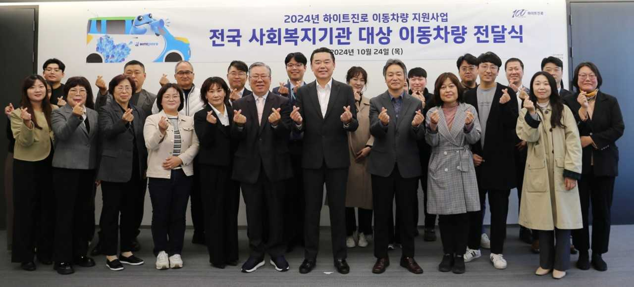 김인규(앞줄 오른쪽 네 번째)하이트진로 대표이사와 사회복지기관 대표 및 관계자가 참석한 가운데 이동차량 전달식이 진행됐다.[하이트진로 제공]
