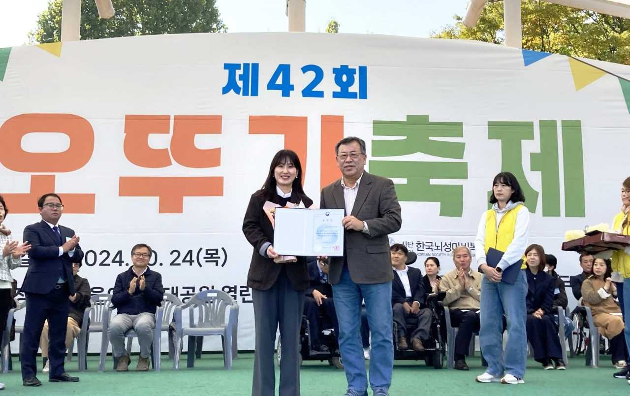 김정우(오른쪽 부터) 한국뇌성마비복지회 회장이 윤보람 유니클로 서스테이너빌리티 매니저에게 보건복지부 장관 표창을 수여하고 있다. [유니클로 제공]