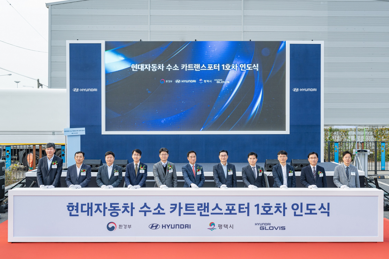 ‘엑시언트 수소전기트럭 카트랜스포터’ 1호차 인도식에서 디앤에이치로지스 오준석(왼쪽부터) 대표, 현대글로비스 SCM사업부장 조삼현 상무, 더불어민주당 홍기원 국회의원, 현대차 전략기획실장 김동욱 부사장, 환경부 대기환경정책관실 오영일 정책관, 정장선 평택시장, 현대차 국내사업본부장 정유석 부사장, 더불어민주당 이병진 국회의원, 경기도 첨단모빌리티산업과 정한규 과장, 경기평택항만공사 김석구 사장, 평택시 환경국 이강희 국장이 기념촬영을 하고 있다.