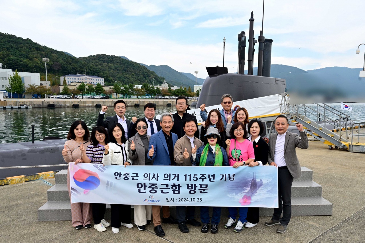 안중근 의사 의거 115주년 기념으로 안중근함을 방문한 메타리치 관계자들이 안중근함을 배경으로 단체촬영을 하고 있다.