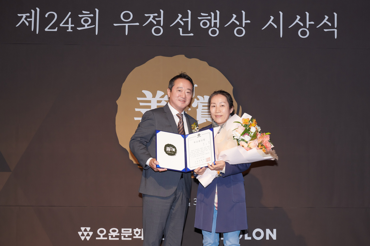 코오롱그룹 오운문화재단 이사장인 이웅열(왼쪽) 코오롱 명예회장이 30일 서울 강서구 마곡동 코오롱 원앤온리센터에서 제24회 우정선행상 대상을 수상한 김선자 씨와 기념촬영을 하고 있다. [코오롱 제공]