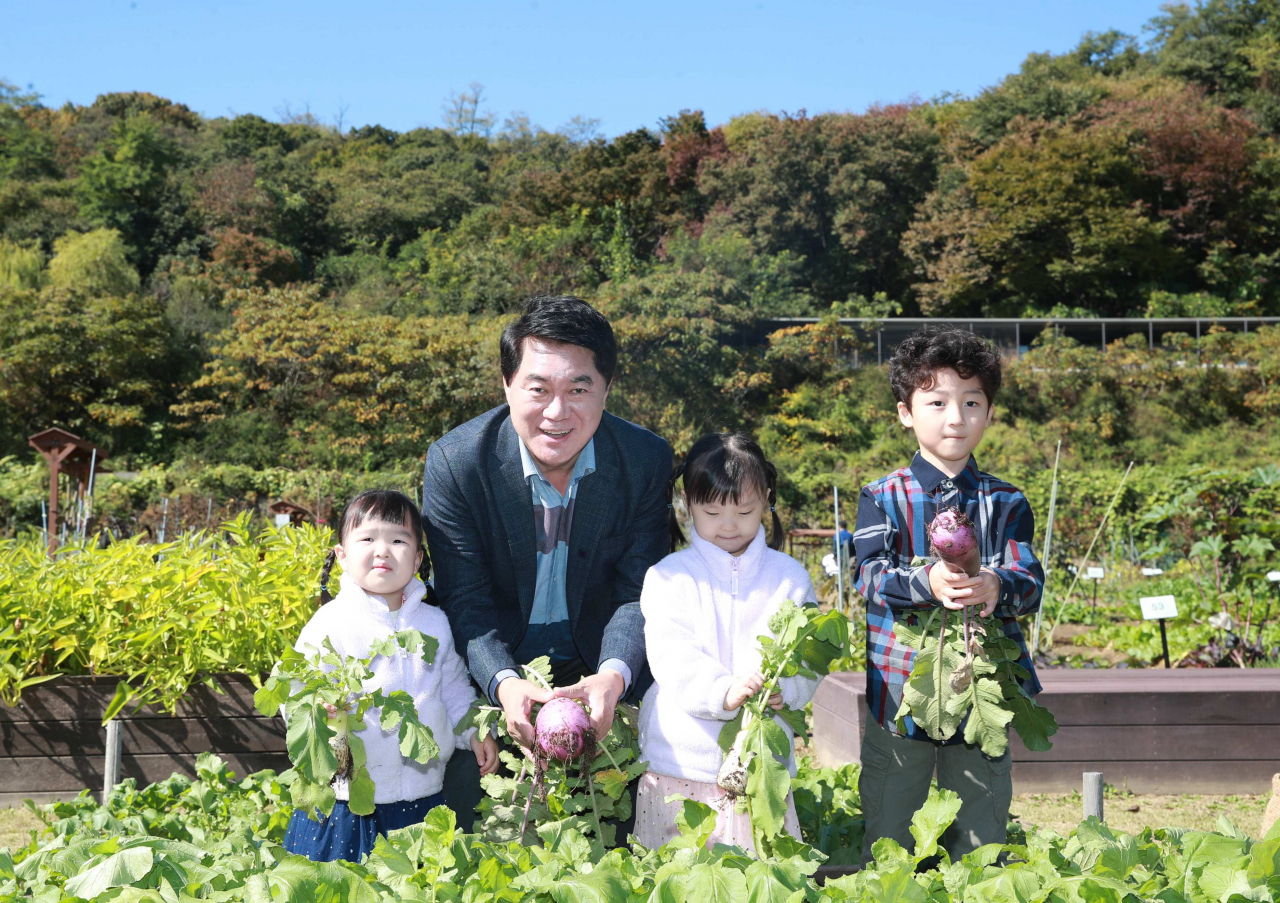 서울 관악구는 오는 9일 오전 10시부터 강감찬 텃밭에서 배추와 무 등을 가족과 함께 수확하는 김장채소 수확체험 행사를 연다. 박준희 구청장이 지난해 행사에서 어린이들과 무를 수확하고 있다.[관악구 제공]