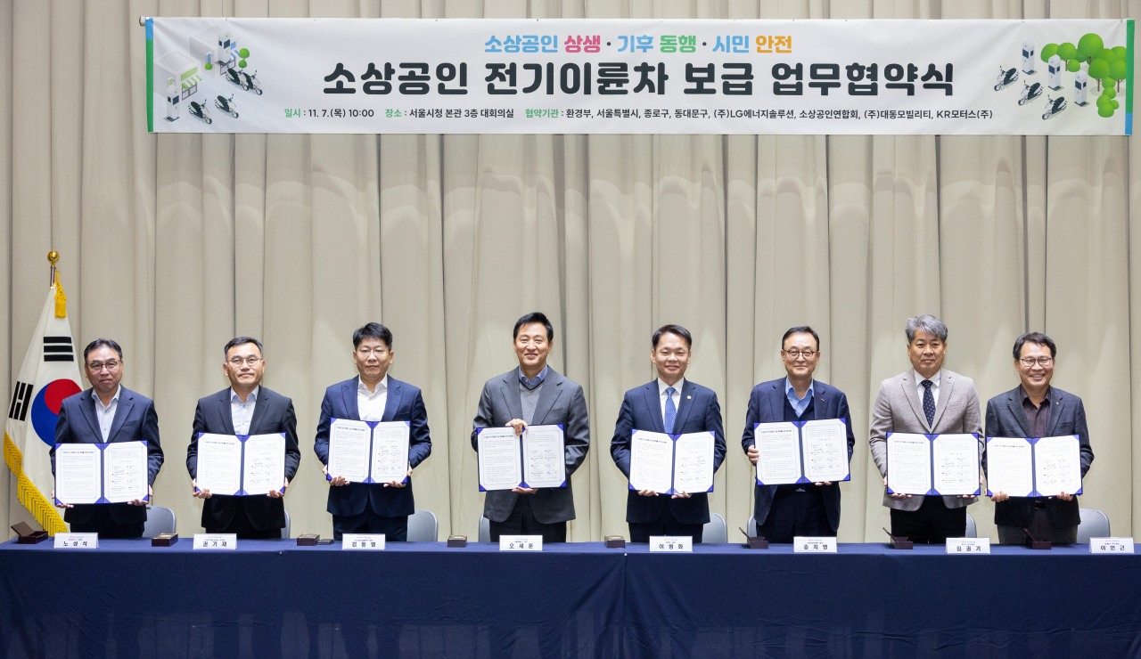 환경부와 서울시는 7일 서울 중구 서울시청에서 소상공인 전기이륜차 보급 확대를 위한 업무협약을 체결했다. 이날 참석한 협약체결 관계자들이 기념촬영을 하고 있다. 사진 왼쪽부터 노성석 KR모터스 대표, 권기재 대동그룹경영실장, 김동명 LG에너지솔루션 사장, 오세훈 서울시장, 이병화 환경부차관, 송치영 소상공인연합회 회장, 김권기 서울 종로구 부구청장, 이인근 서울 동대문구 부구청장[환경부 제공]