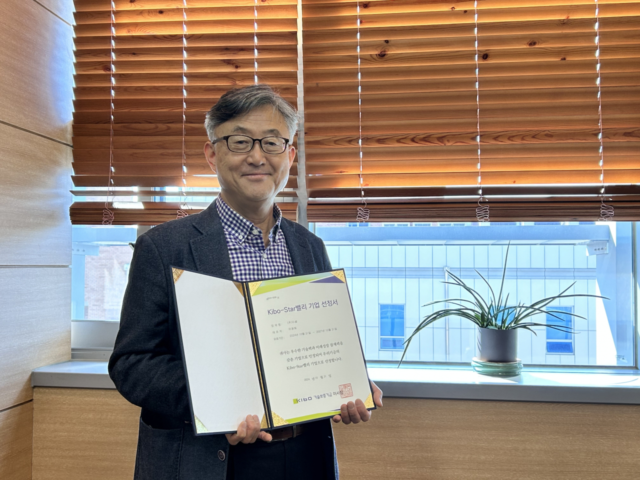 이광희 ㈜리셀 대표가 중소벤처기업부 산하 기술보증기금 ‘Kibo-Star 밸리 기업’ 선정서를 들어 보이고 있다. [GIST 제공]