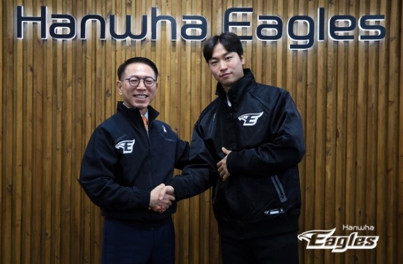 엄상백(오른쪽)이 8일 한화 이글스와 FA 계약을 한 뒤, 박종태 대표이사와 악수하고 있다. [한화 이글스]