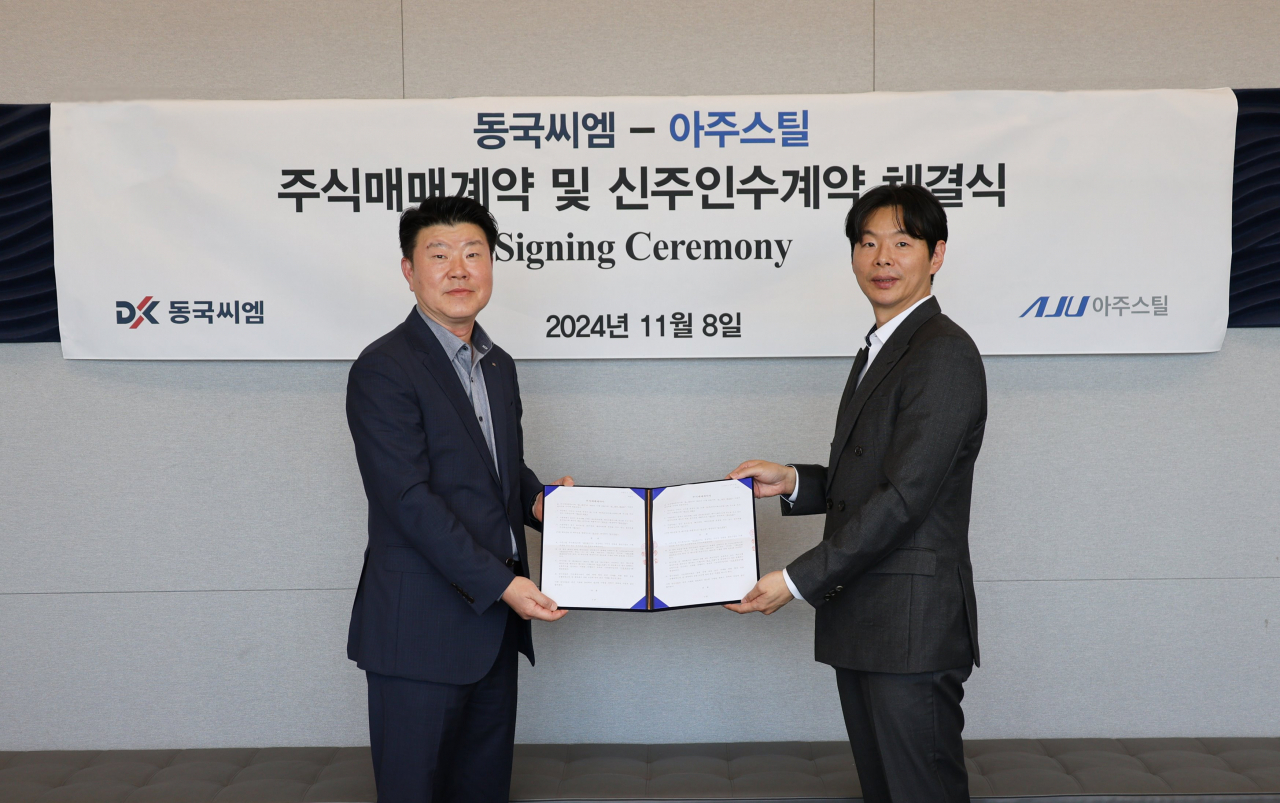 동국씨엠-아주스틸 주식매매계약 및 신주인수계약 체결식에서 이현식(왼쪽) 동국씨엠 영업실장과 이영세 아주스틸 경영전략부문장이 기념촬영을 하고 있다. [동국씨엠 제공]
