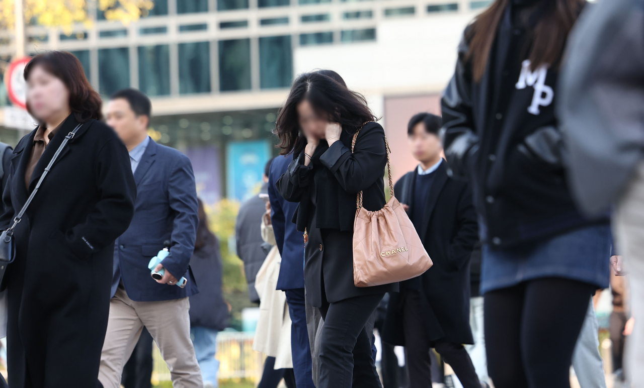 쌀쌀한 아침 기온을 보이는 5일 오전 서울 광화문광장에서 시민들이 두꺼운 옷차림을 한 채 걸어가고 있다. [연합]