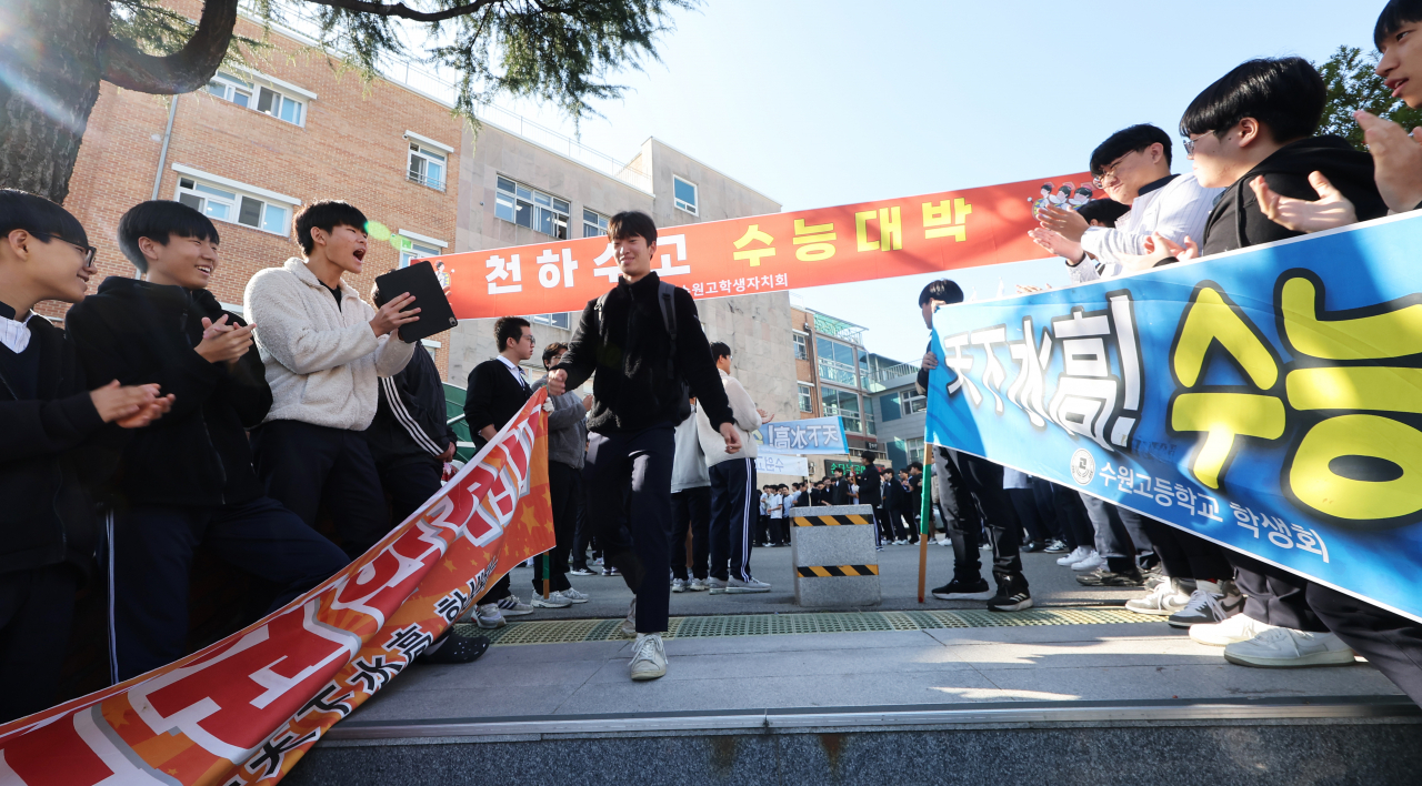 경기도 수원시 팔달구 수원고등학교에서 3학년 학생들이 후배들의 수능 응원을 받으며 교정을 나서고 있다. [연합]