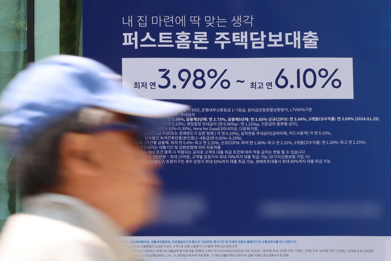 서울 한 시중은행의 대출 안내문 앞을 시민이 지나가고 있다.[연합]