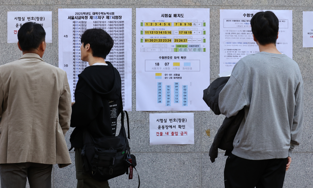 2025학년도 대학수학능력시험을 하루 앞둔 13일 서울 한 고등학교에서 수험생들이 가벼운 옷차림으로 고사장을 확인하고 있다. 기상청은 수능일인 14일은 평년에 비해 기온이 높을 것으로 예상했다. [연합]