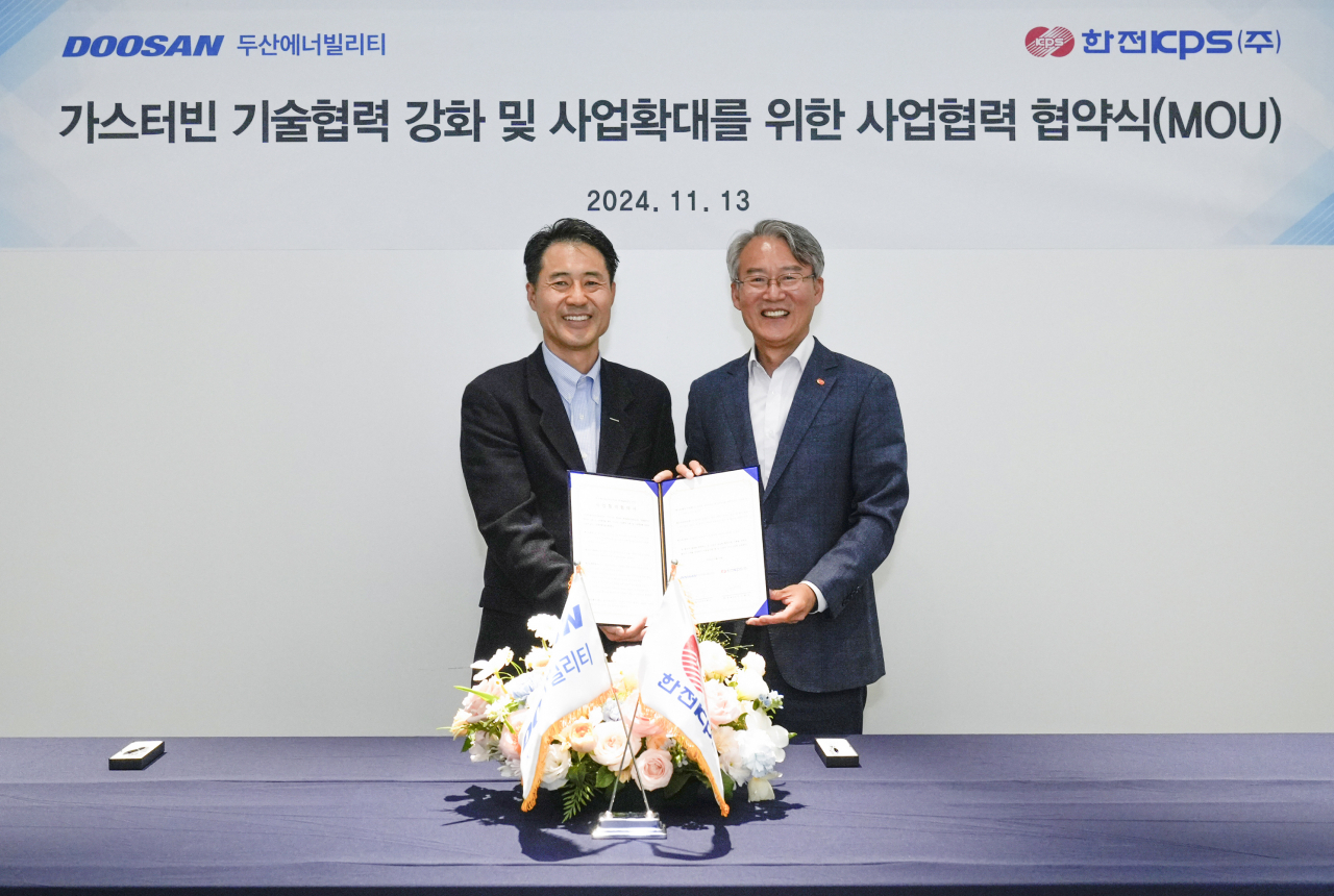 손승우(왼쪽) 두산에너빌리티 파워서비스 BG장과 김도윤 한전KPS 발전안전사업본부장이 지난 13일 경기 분당두산타워에서 열린 ‘가스터빈 기술 협력 강화와 사업 확대를 위한 협력 협약(MOU)’ 체결식에서 기념촬영을 하고 있다. [두산에너빌리티 제공]