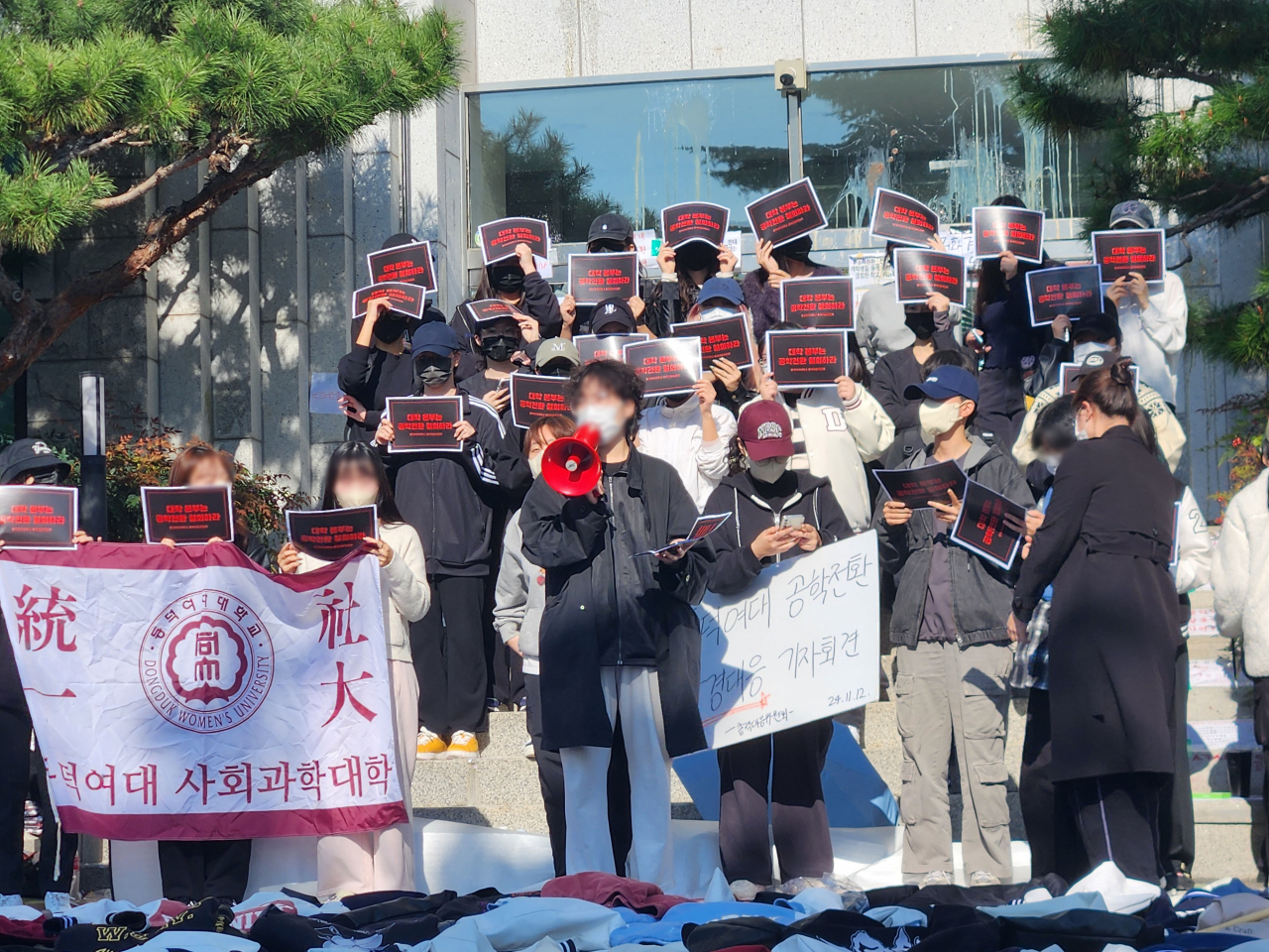 동덕여자대학교의 남녀공학 전환 추진 논의에 반발한 학생들이 12일 오전 서울 성북구 동덕여대 본관 앞에서 열린 기자회견에서 손팻말을 들고 있다. [연합]