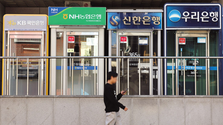 서울 시내 한 거리에 설치된 은행 ATM기기 앞을 시민이 지나가고 있다. [연합]