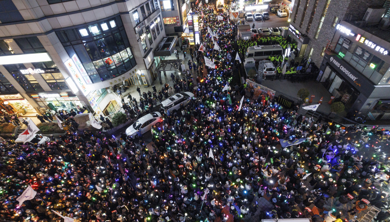 Citizens take part in a candlelight vigil near the National Assembly in Yeouido, Seoul, on Thursday afternoon, protesting President Yoon Suk Yeol’s martial law declaration. During the march, participants surrounded the People Power Party headquarters, chanting slogans demanding Yoon’s impeachment and the dissolution of the party. (Yonhap)