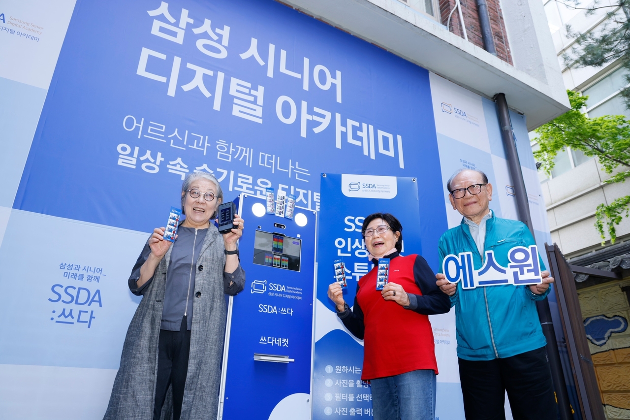 에스원 디지털 기기 체험을 마친 시니어들이 카메라를 향해 환하게 웃고 있다