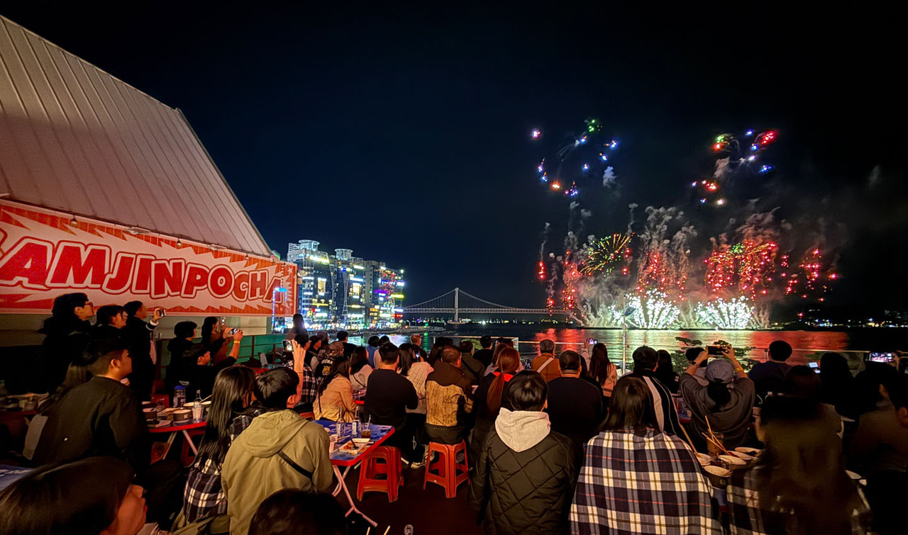 부산 광안리에 위치한 ‘삼진포차’에서 방문객들이 부산불꽃축제를 관람하고 있다. [사진=삼진어묵]