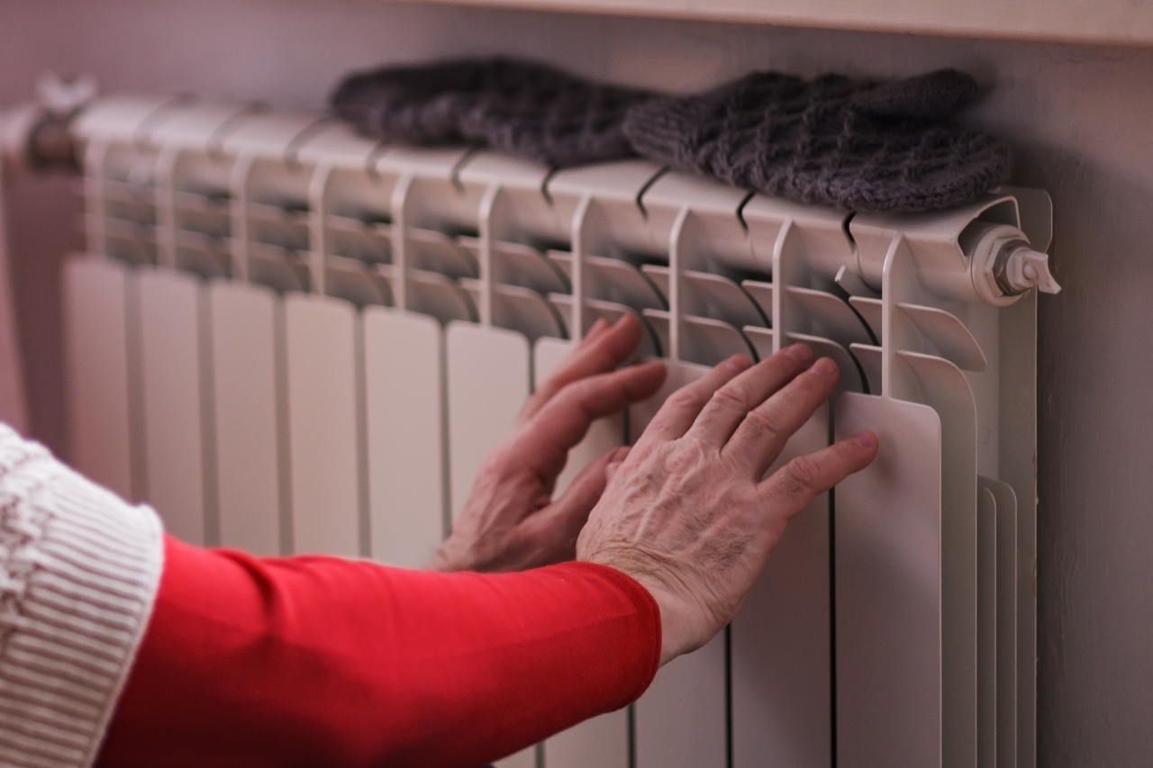 Man feeling cold at home with home heating trouble