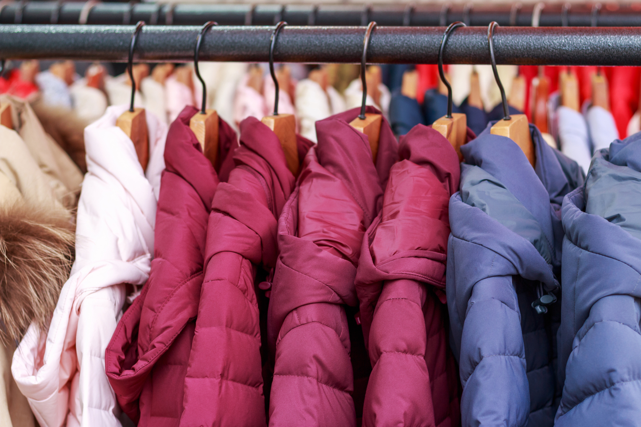 Winter multicolored jackets on hanger in the store close-up