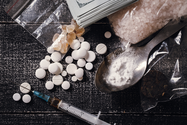 Hard drugs on dark table. Drug syringe and cooked heroin