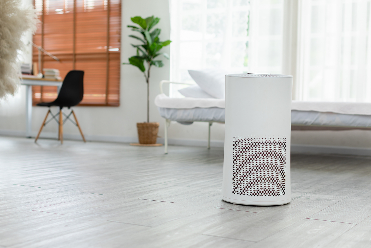 Air purifier in cozy white bedroom for filter and cleaning remov