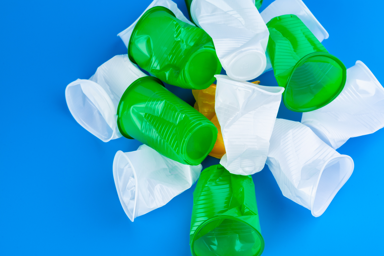 Crumpled empty single-use plastic cups, studio shot. Plastic pollution concept