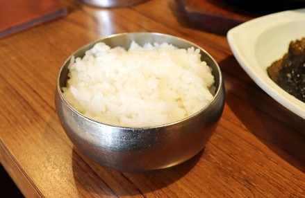 A bowl of white rice in a stainless steel bowl.