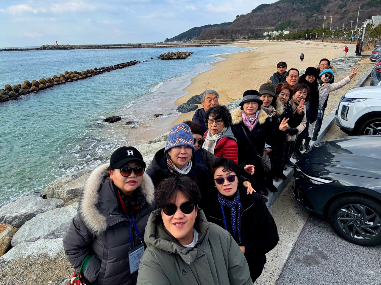 철도 여행 참여자들이 울진 바다를 배경으로 기념 촬영을 하며 즐거워하고 있다(울진군 제공)
