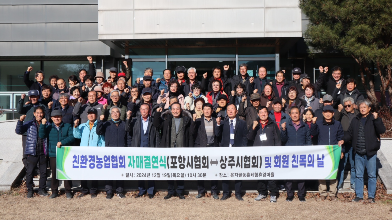 상주친환경농업 협회 와 포항시 친환경농업 협회가 자매결연을 맺은 후 각 단체 회원들이 기념사진을 찍으며 파이팅을 외치고 있다(상주시 제공)