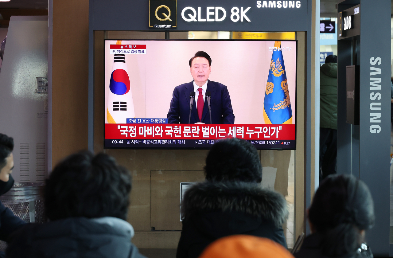 People watch as President Yoon Suk Yeol delivers an address Dec. 12. (Yonhap)