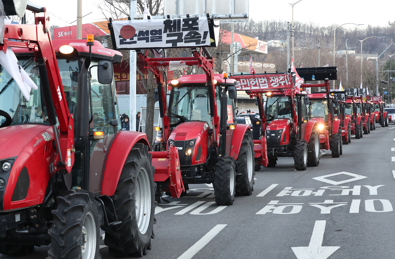Tractors continue their march toward the presidential residence in Hannam-dong in central Seoul on Sunday afternoon, after being blocked by police and their buses for around 28 hours near Namtaeryeong Pass in southern Seoul since Saturday noon. Members of the Korean Peasants League have driven dozens of tractors and cargo trucks, calling for the arrest and resignation of President Yoon Suk Yeol, while criticizing his short-lived martial law declaration on Dec. 3. (Yonhap)