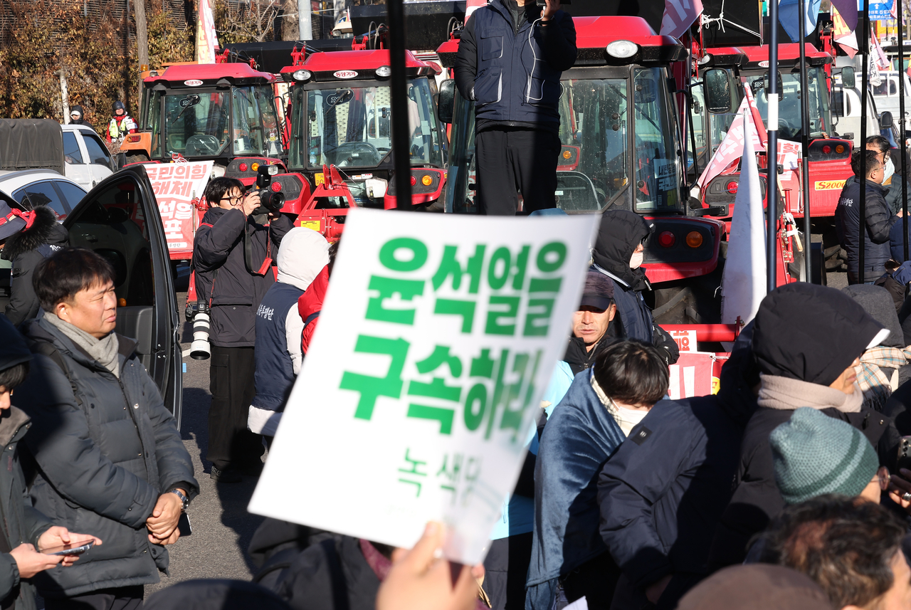 Tractors from the Korean Peasants League, which staged a protest calling for the arrest of President Yoon Suk Yeol, are seen stopped near Namtaeryeong Pass in Seocho-gu, Seoul, Sunday, following more than a daylong standoff with police. A sign reading "Arrest Yoon Suk Yeol" is visible at the scene. Yonhap