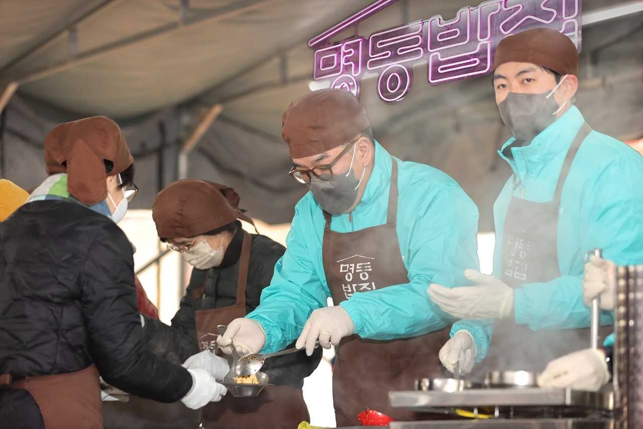 Hana Financial Group Vice Chairman Lee Eun-hyung (second from right) helps prepare a meal on Friday at a soup kitchen in Myeongdong Cathedral, central Seoul. Hana Financial covered meals for 1,111 people at the soup kitchen named Myeongdong Babjib, run by the One Body One Spirit, a religious organization within the Archdiocese of Seoul. Hana Financial employees and members of the Myeong-dong Merchants Association volunteered to provide warm meals to those in need. (Hana Financial Group)