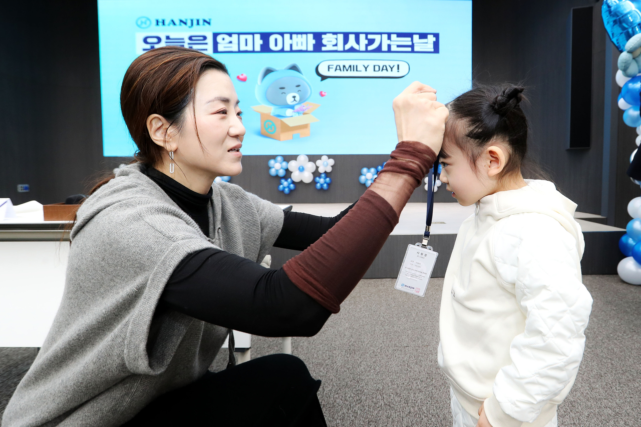 한진 조현민 사장이 부모님 회사에 찾아온 자녀들의 목에 명예 사원증을 걸어주고 있다. [한진 제공]