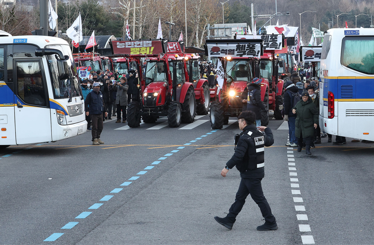 Police busses that had formed a blockade against the farmer protestors since Saturday afternoon are evacuating the site on Sunday, at the Namgaeryeong Pass in Seocho-gu, Seoul. (Yonhap)
