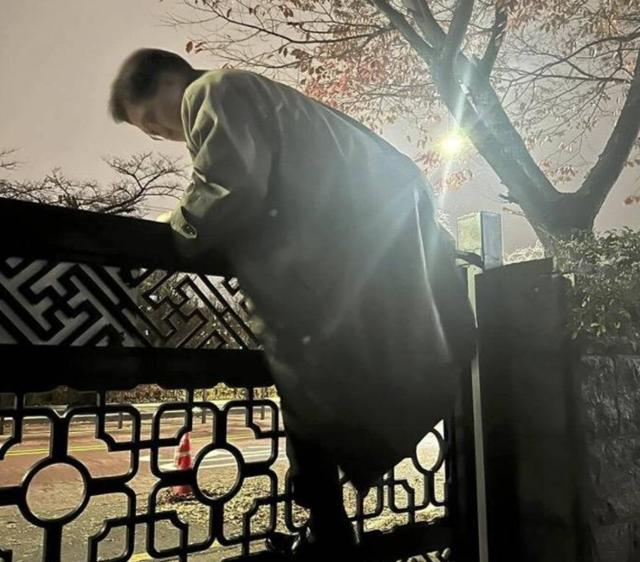Speaker Woo Won-shik climbs over a wall to enter the National Assembly following the declaration of martial law on the night of Dec. 3. Captured from Woo Won-shik’s Facebook account