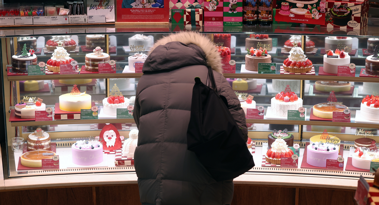 A customer browses Christmas cakes on display at a Paris Baguette branch in Seoul on Christmas Eve, Tuesday. (Yonhap)