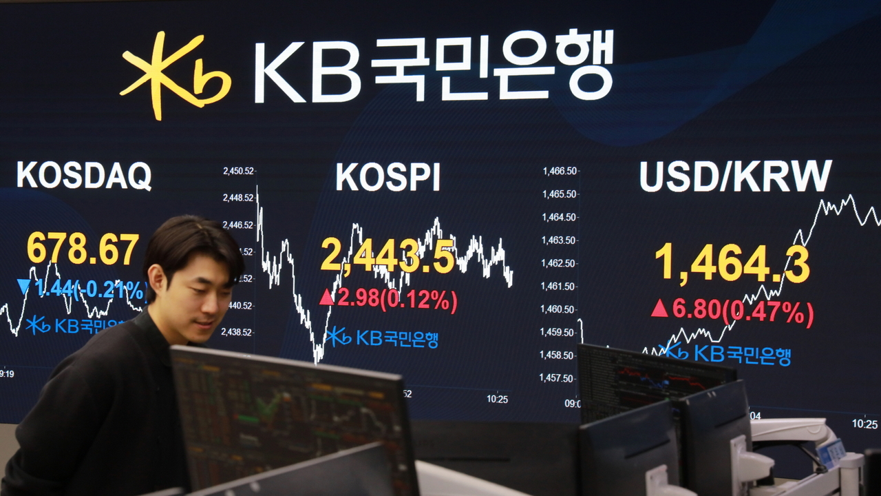 An employee at KB Kookmin Bank's dealing room walks past a display in Seoul, Thursday. (KB Kookmin Bank)