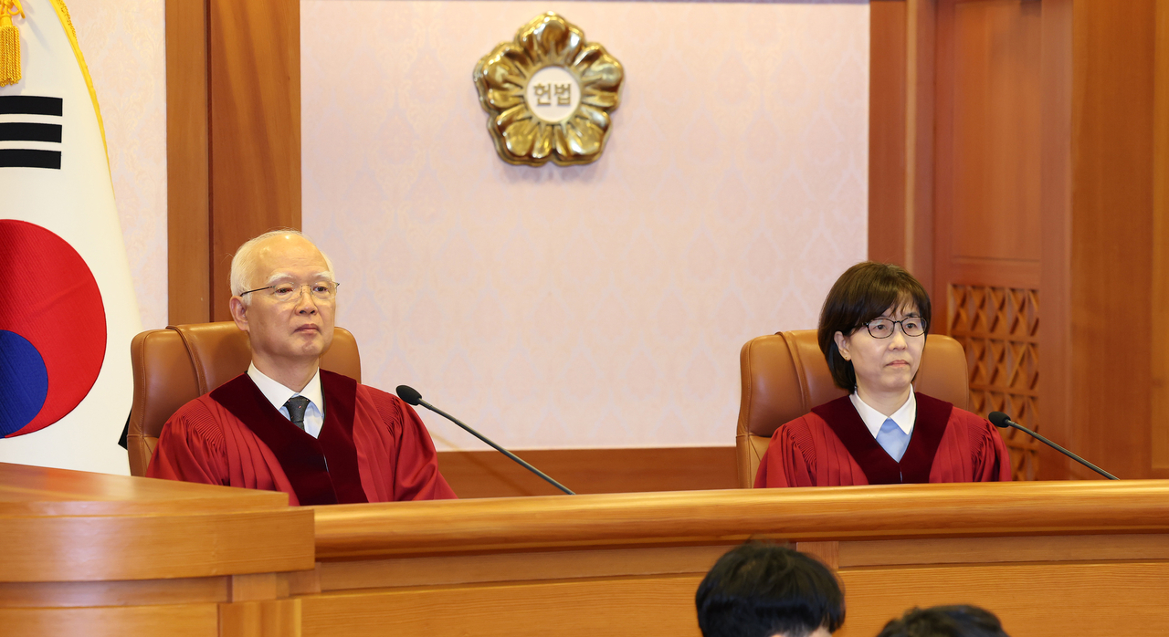 Justices Jeong Hyun-sik (left) and Lee Mi-sun attend the first preparatory hearing held at the Constitutional Court in Jongno-gu, Seoul, Friday. (Yonhap)