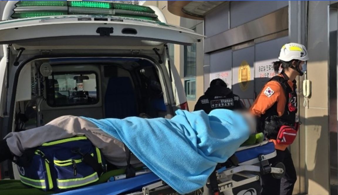 A flight attendant rescued from the deadly plane crash at Muan International Airport is taken into Mokpo Hankook Hospital in Mokpo, South Jeolla Province, Sunday. (Yonhap)