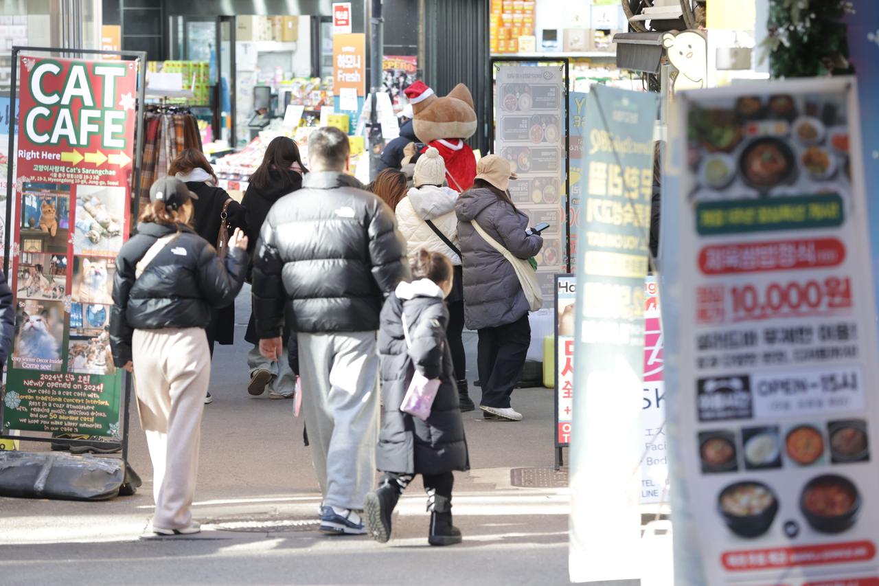 Pedestrians pass by restaurants in Seoul, Dec. 22. (Yonhap)