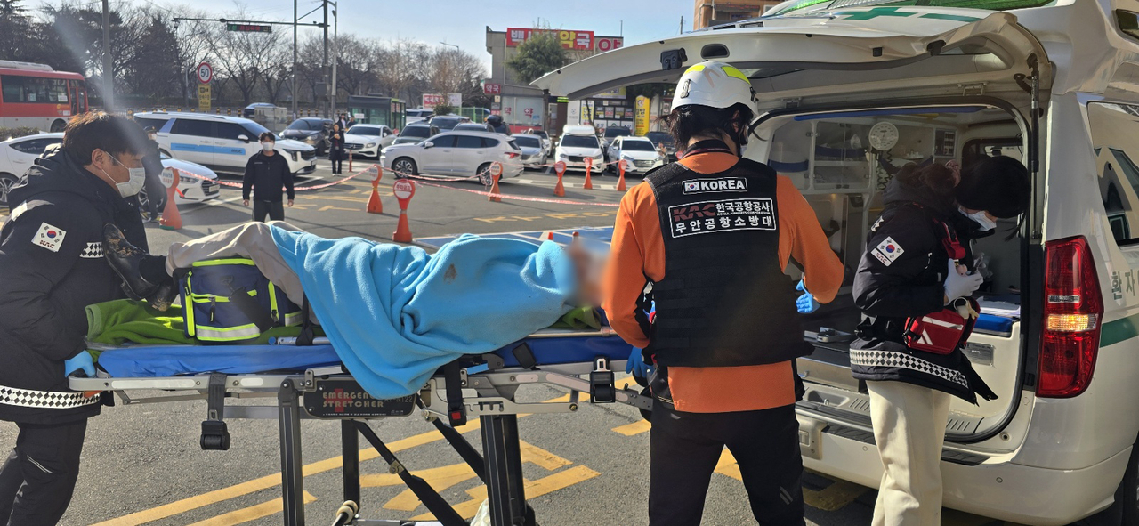 One of the flight attendants rescued from a plane crash at Muan International Airport in South Jeolla Province is transferred to a hospital in Mokpo city on Sunday. (Yonhap)