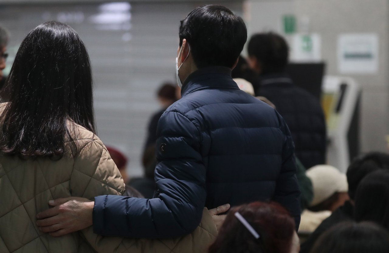 Family members of victims of the Jeju Air plane crash listen to firefighting officials' announcement of the names of the dead at Muan International Airport in Muan, 288 kilometers southwest of Seoul, on Sunday.  (Yonhap)