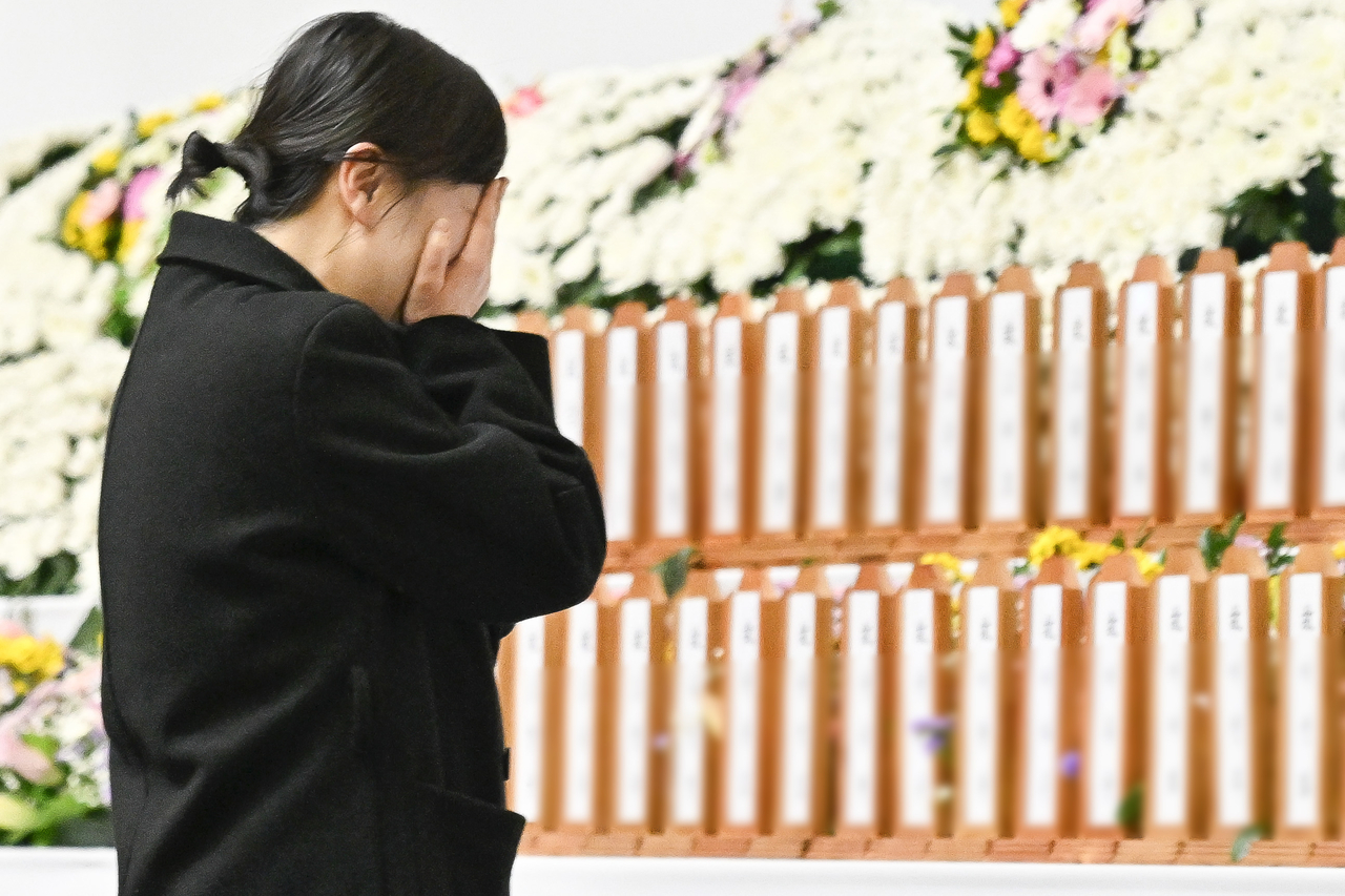 A mourner cries while paying respects to victims of Sunday’s Jeju Air flight 7C 2216 crash, at a joint memorial in Muan, South Jeolla Province, Monday. (Yonhap)