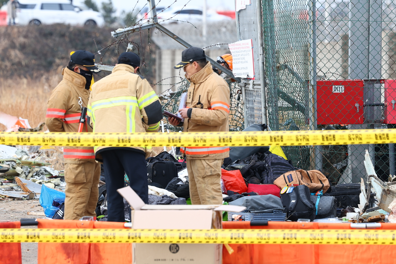 Bags and suitcases belonging to passengers are seen at the site of the Jeju Air plane crash and explosion at Muan International Airport in South Jeolla Province, Monday. (Yonhap)