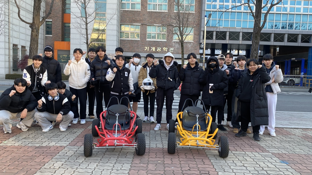 학생들이 직접 제작한 경량 모빌리티를 시승하고 기념사진을 촬영하고 있다.[영남이공대 제공]