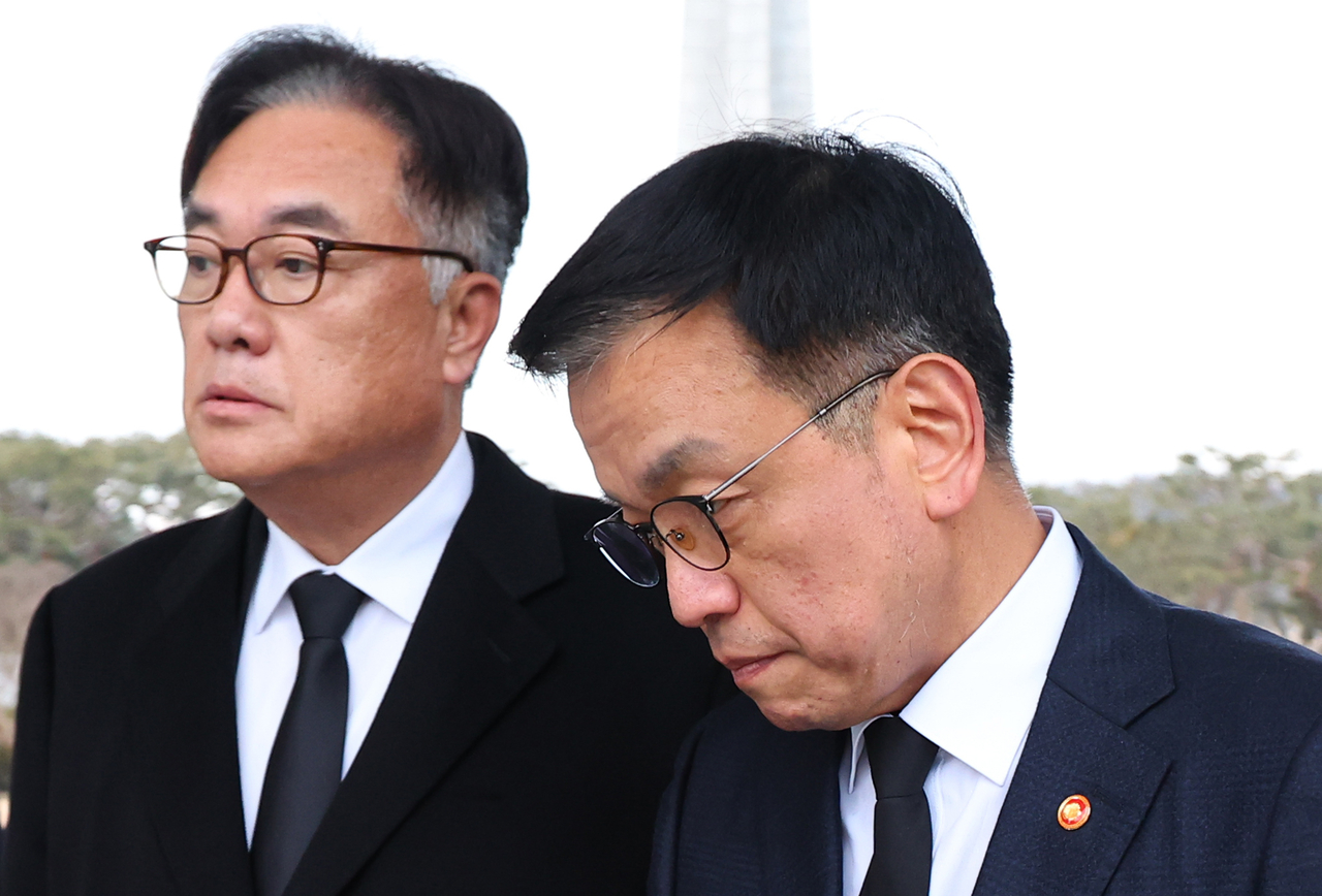 Presidential chief of staff Chung Jin-suk (left) and acting President Choi Sang-mok walk side by side at the Seoul National Cemetery, Wednesday. Yonhap