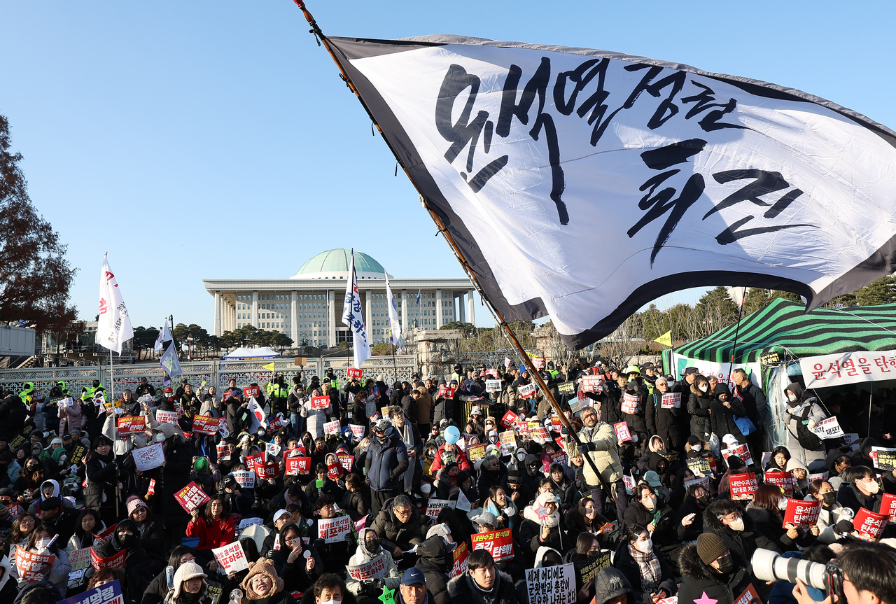 Protesters gather in front of the National Assembly in Seoul on Dec. 14, ahead of the parliamentary plenary session to vote on a motion to impeach President Yoon Suk Yeol. (Yonhap)