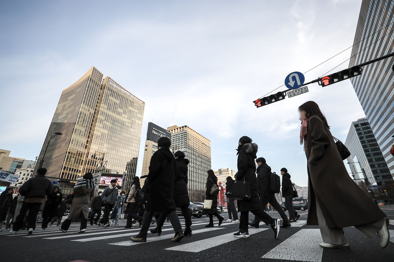 Office workers commute through Gwanghwamun Square in central Seoul on Thursday, the first weekday of the new year. (Newsis)