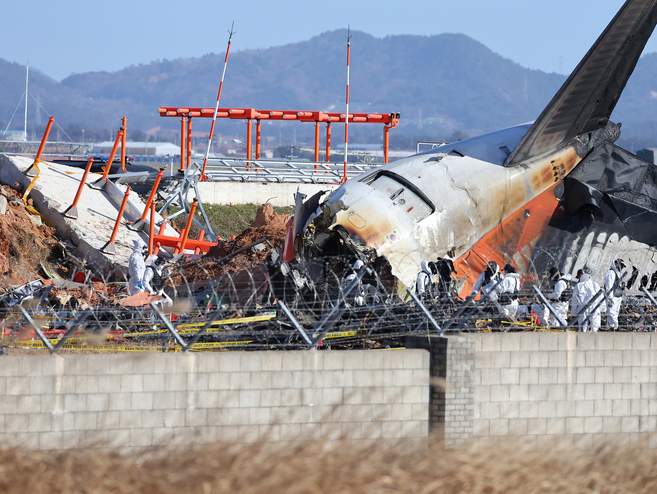 지난달 31일 전남 무안군 무안국제공항 제주항공 여객기 참사 현장에서 경찰 과학수사대와 국과수가 현장 조사를 하고 있다. 여객기 참사 원인으로 부상한 콘크리트 둔덕과 로컬라이저(방위각 시설)가 처참히 부서져 있다. [연합]