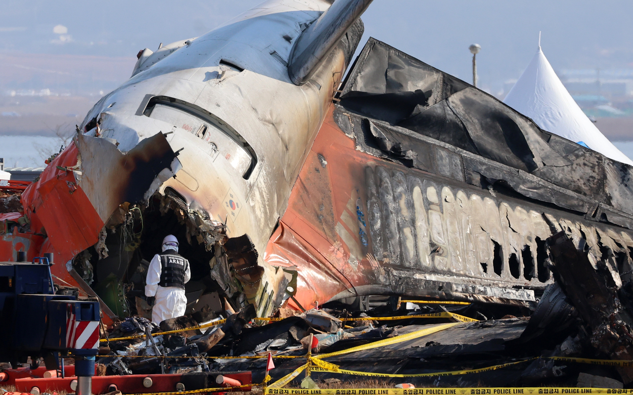 An official investigates inside the aircraft that crashed at Muan International Airport in South Jeolla Province, Sunday. (Yonhap)